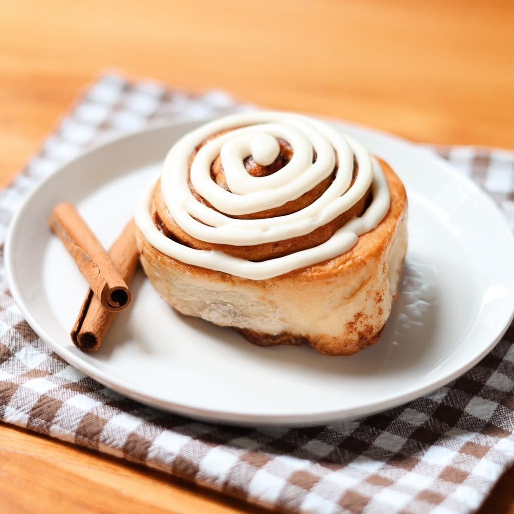 Cinnamon roll con frosting sobre una servilleta de cuadros