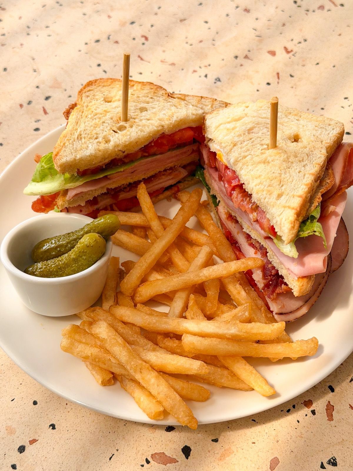 Club sandwich con papas y pepinillos, del almuerzo entre semana