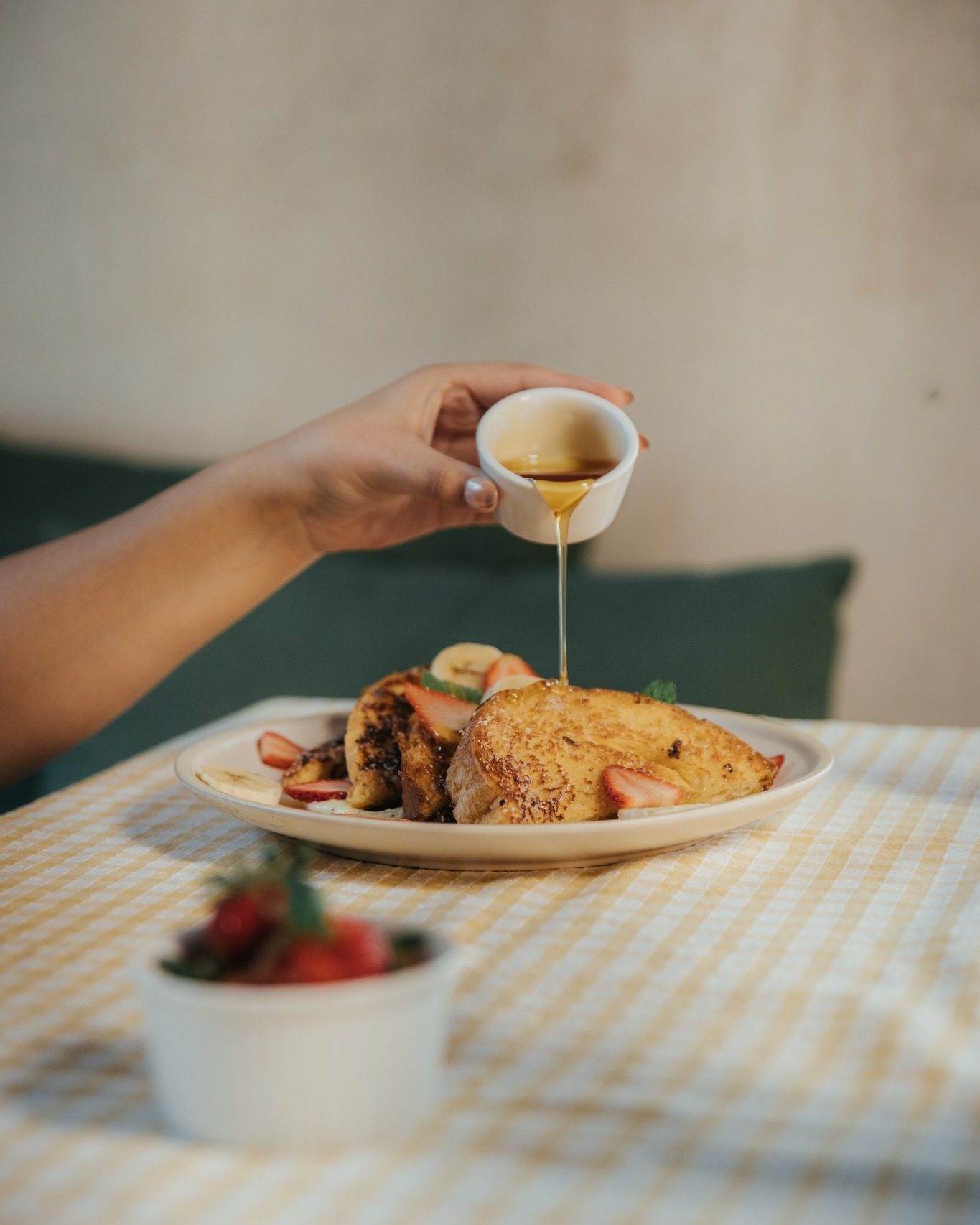 French toast con una mano sirviendo miel de maple